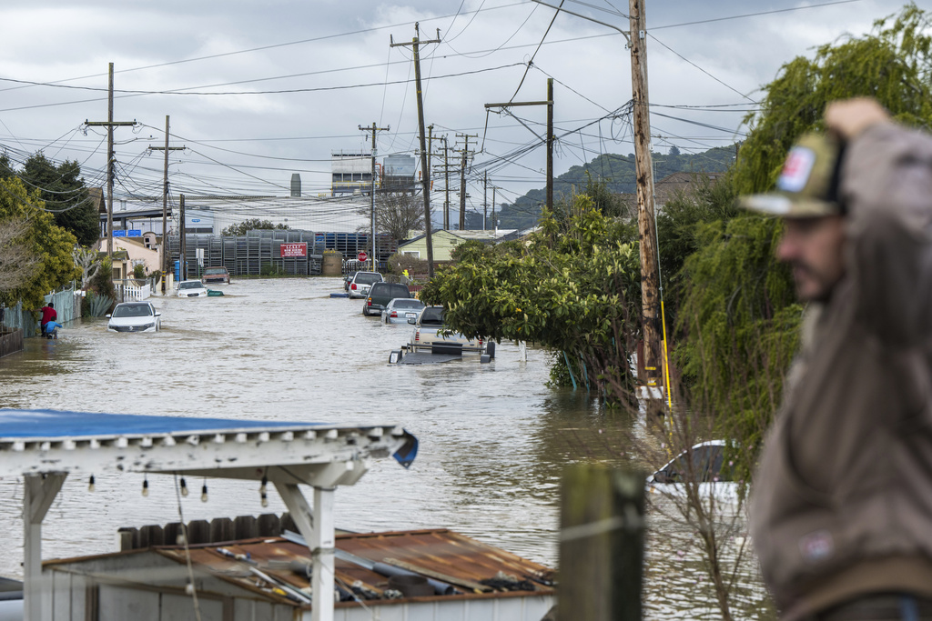 A man looks out over floodwaters in Watsonville, Calif.