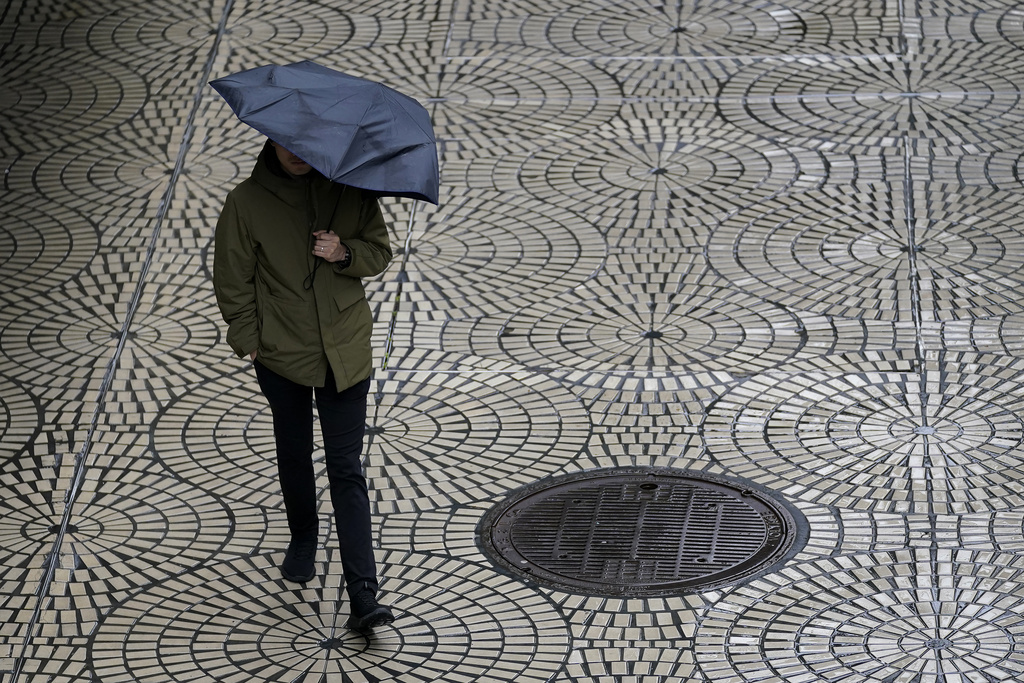 A pedestrian carries an umbrella while walking in San Francisco