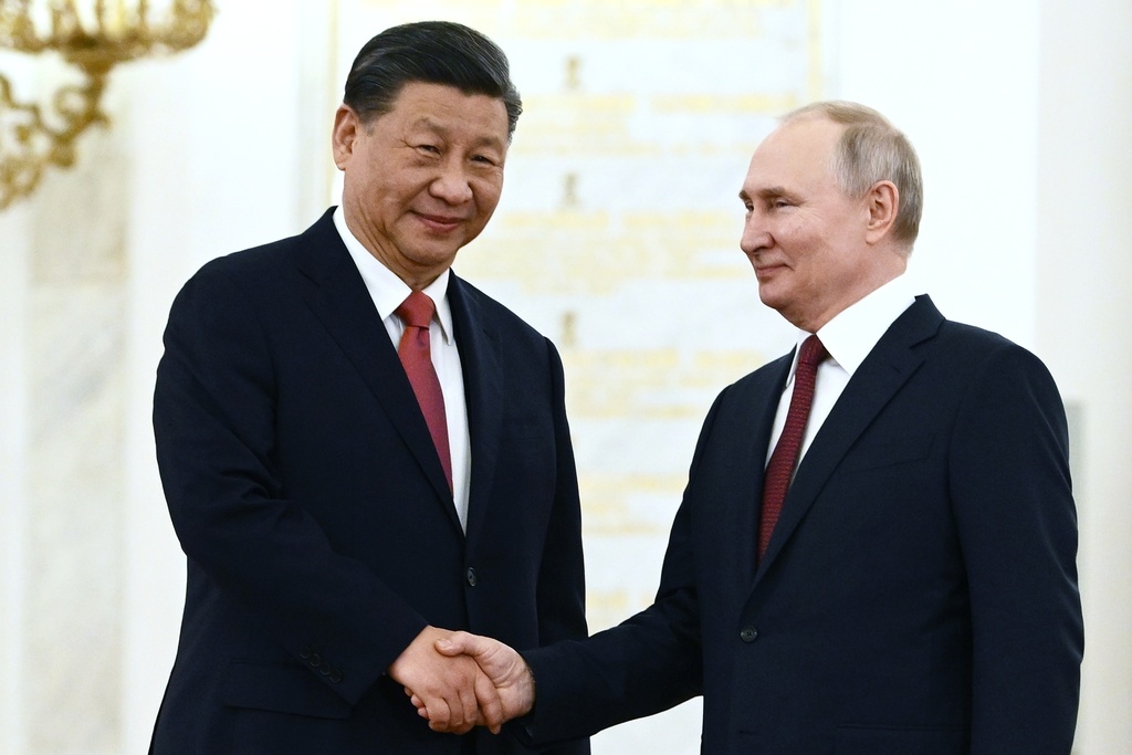 Russian President Vladimir Putin, right, and Chinese President Xi Jinping shake hands during an official welcome ceremony at The Grand Kremlin Palace