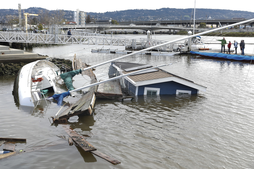 A boat and houseboat float submerged at Jack London Aquatic Center after the boat from a neighboring marina hit the houseboat during a storm