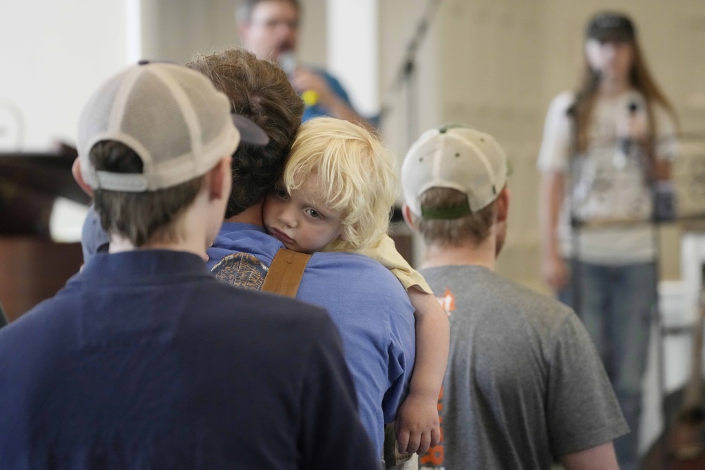 Emmett Nichols, 2, clings to his father Martin Nichols as the family attends service at the First Baptist Church in Rolling Fork, Miss.