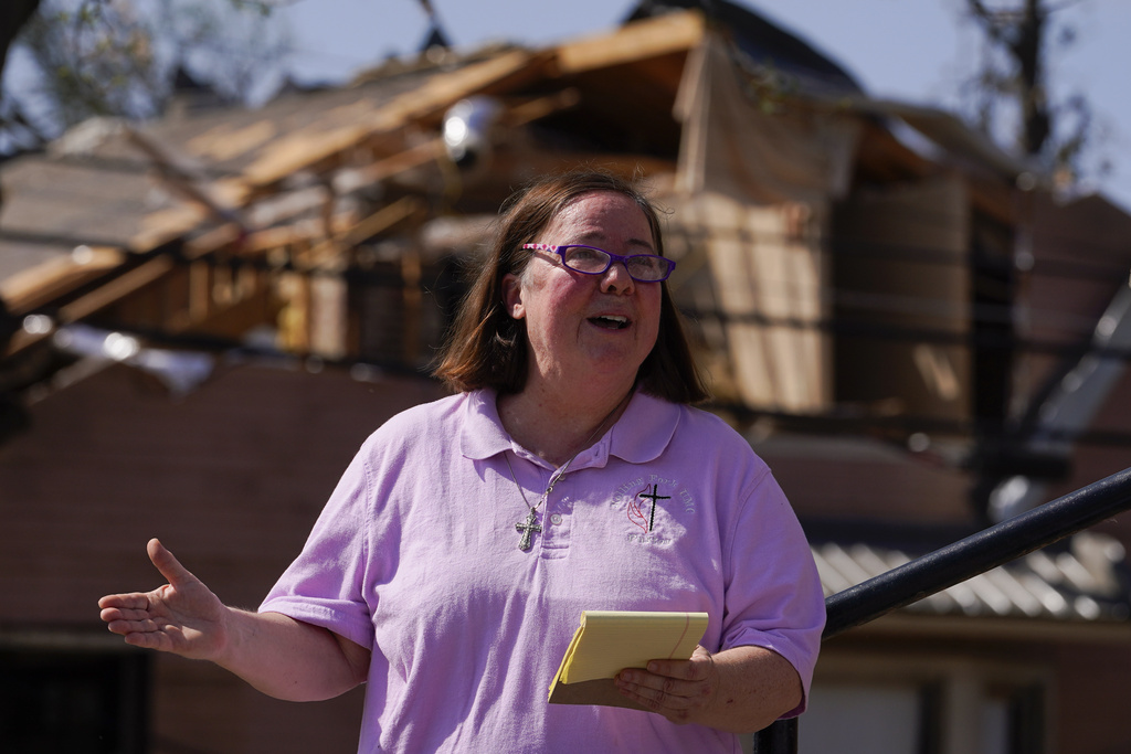 Rev. Mary Stewart, of Rolling Fork United Methodist Church, leads a prayer as people worship on the steps of the church