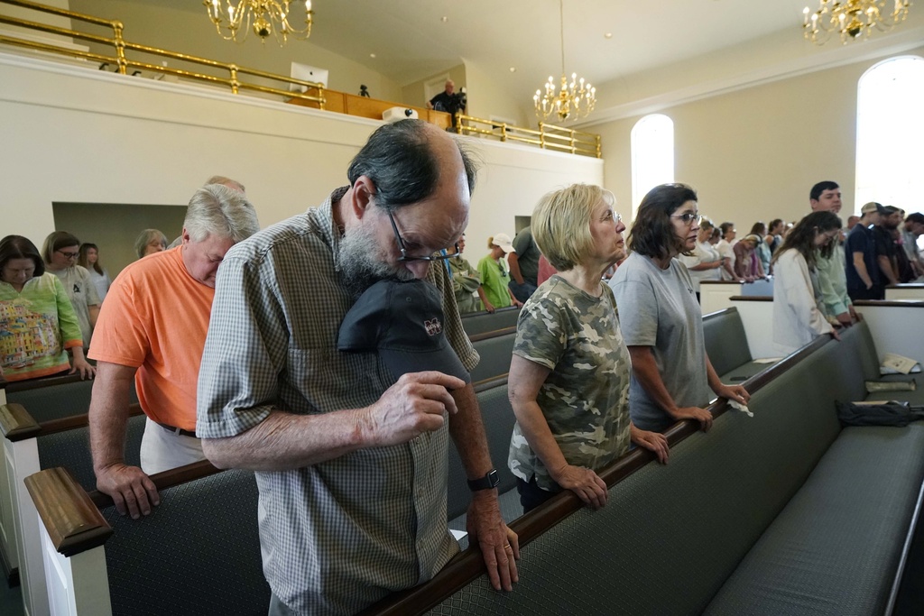 Members bow their heads in prayer during a service at the First Baptist Church in Rolling Fork, Miss.