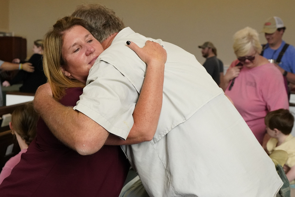 First Baptist Church of Rolling Fork, Miss., members Ashley Nichols, left, and Dale White hug each other prior to the Sunday morning service