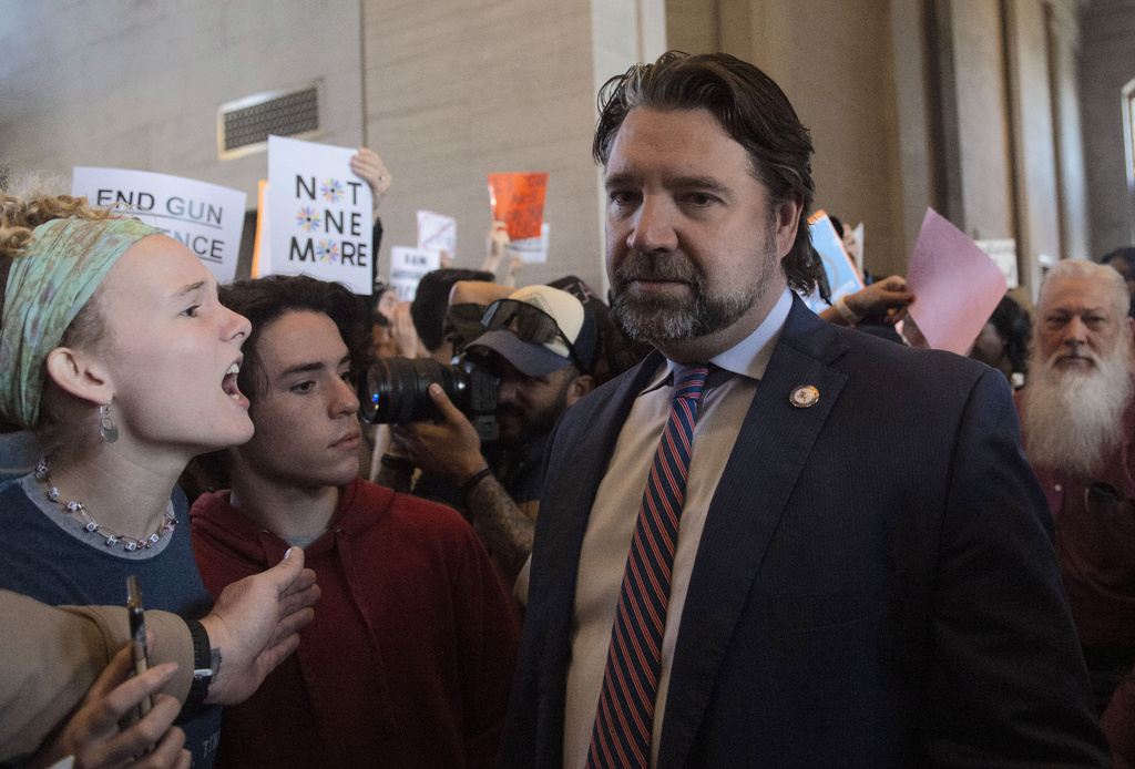 Protesters fill the capitol building as representatives make their way towards the House chamber doors at the State Capitol Building