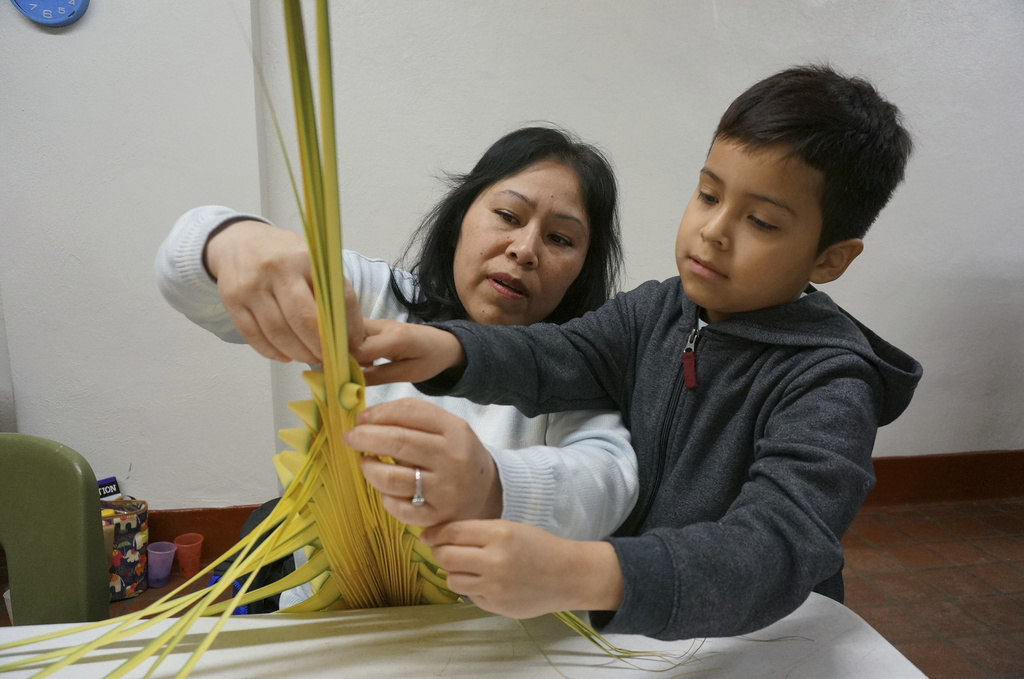 Maria Consuelo Palapa weaves a palm frond in a traditional Mexican design with help from her son Omar, 7, at the Church of the Incarnation in Minneapolis