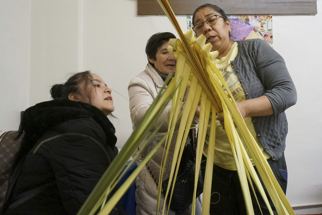 Isabel Tenorio, right, teaches how to weave palm fronds into elaborate designs to Kari Mendoza, left, and her mother, Maria Teresa Mendoza, at the Church of the Incarnation in anticipation of Palm Sunday in Minneapolis