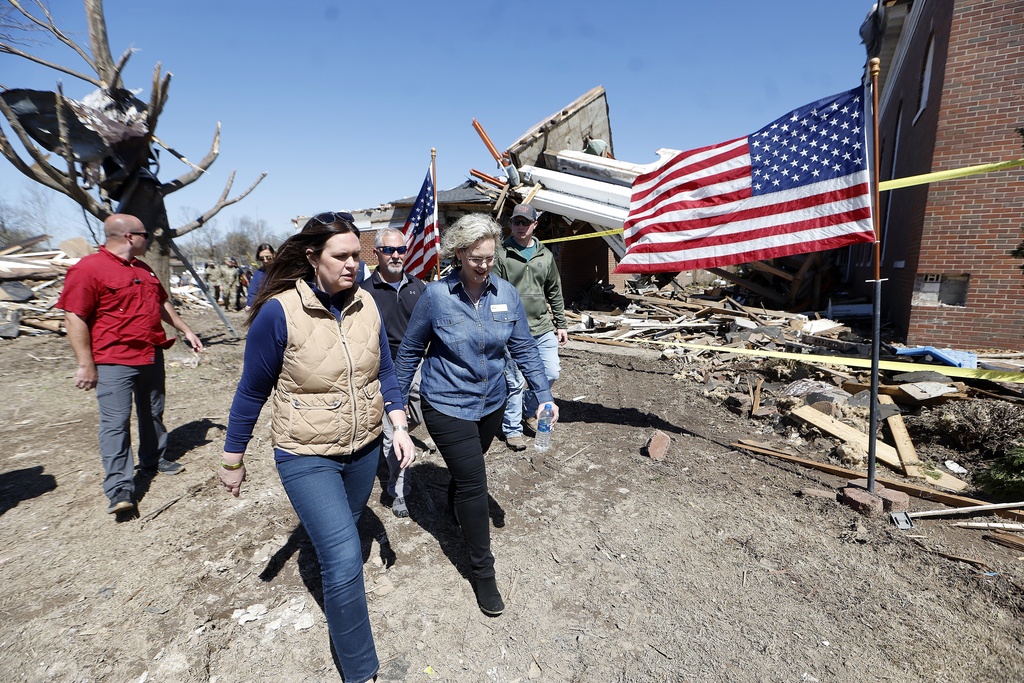 Arkansas Gov. Sarah Huckabee Sanders, front left, talks with Wynne Mayor Jennifer Hobbs, front right, as they tour storm damage outside the First United Methodist Church in Wynne, Ark.