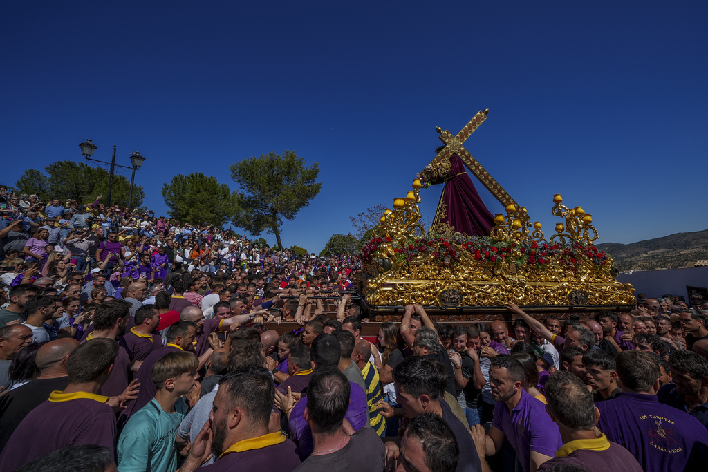 Penitents of the "Padre Jesus Nazareno" brotherhood carry a portable dais platform which supports a statue of Jesus Christ carried by "costaleros"during the holy week procession in Priego de Cordoba, southern Spain, Friday, April 7, 2023.