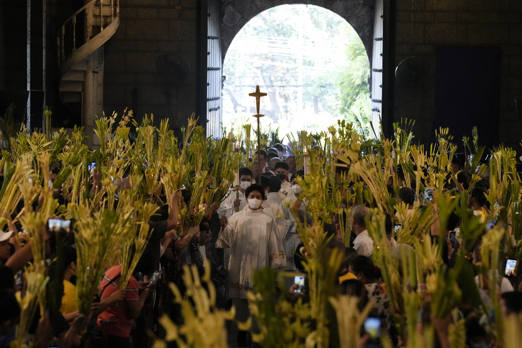 Catholic devotees wave their palm fronds during rites to commemorate Palm Sunday, which marks the entry of Jesus Christ into Jerusalem, Sunday, April 2, 2023 in Manila, Philippines.