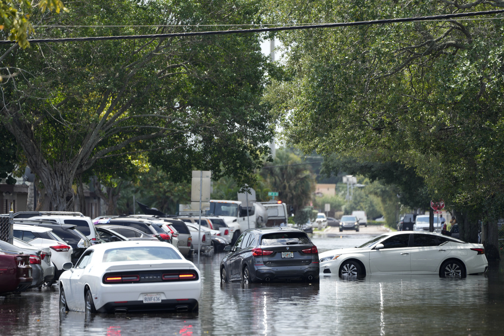 Waterlogged vehicles sit abandoned amid receding floodwaters in the Durrs neighborhood of Fort Lauderdale, Fla.