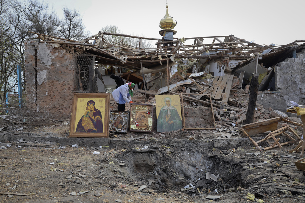 People save icons as they clear the rubble after a Russian rocket ruined an Orthodox church in rocket attack on Easter night