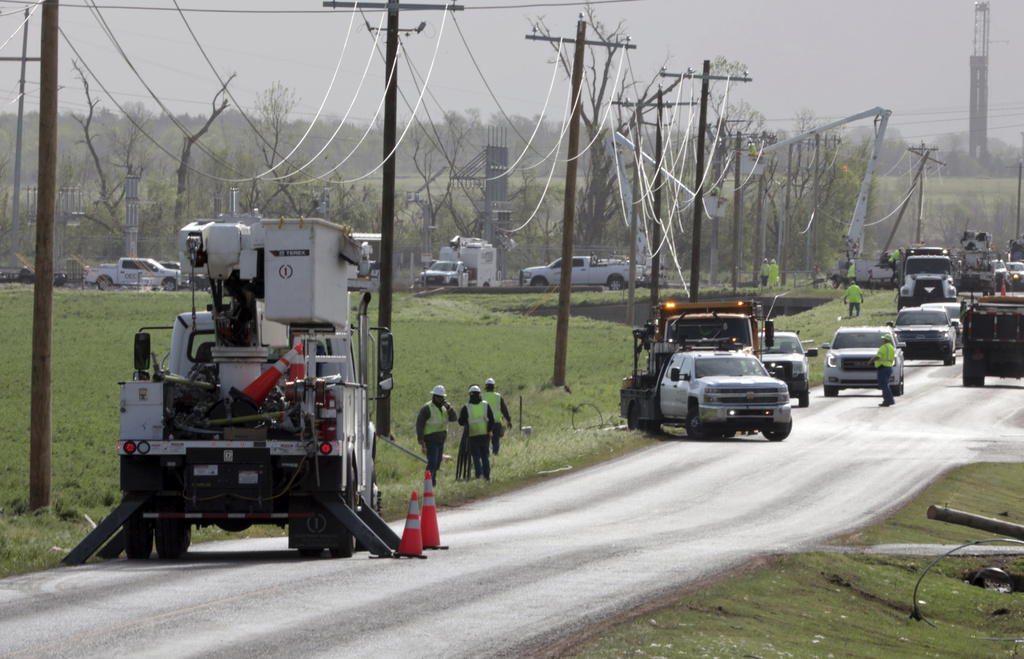 Linemen repair damage to utility poles and wires in Cole, Okla. 