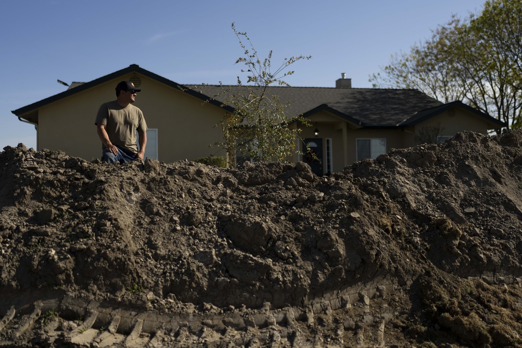 Earl Gomes outside his home with a berm he built to protect the property from possible flooding of the Kings River in the Island District of Lemoore, Calif.