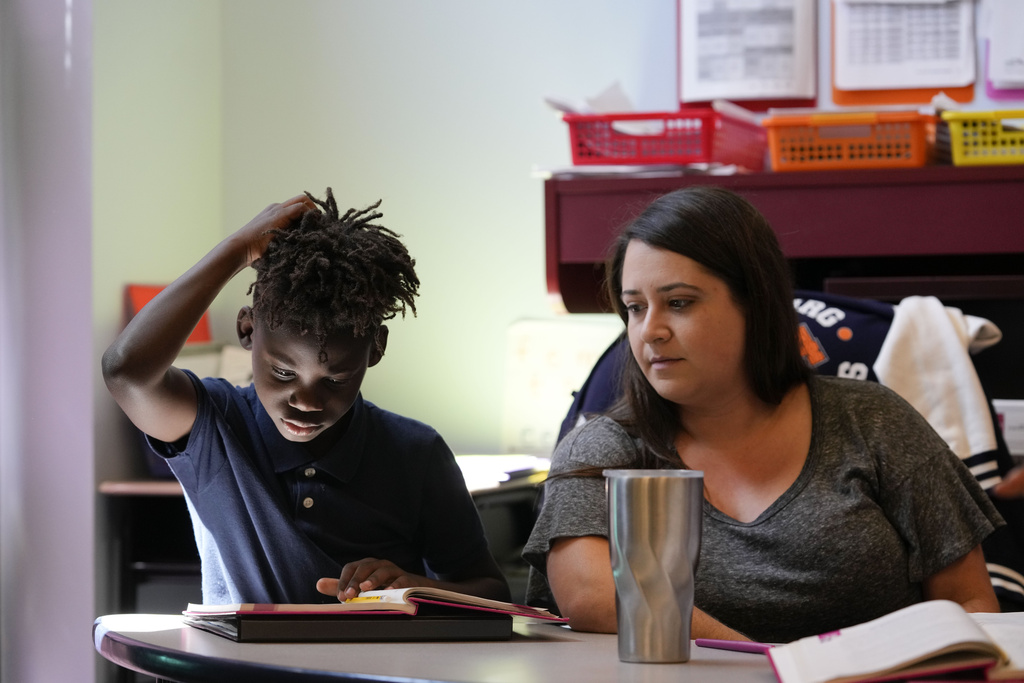 Literacy interventionist Liz Snapp talks with third grader Jakeem Henderson, 8, at Schaumburg Elementary