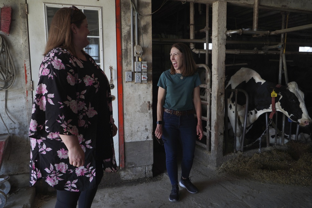 Rev. Jillene Gallatin, of Grace Lutheran Church, right, visits with congregant Cassie Eldeen, whose family owns a dairy farm in Waseca, Minn.