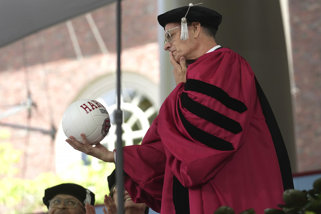 Actor Tom Hanks examines a ball as part of a spoof during Harvard University commencement exercises on the school