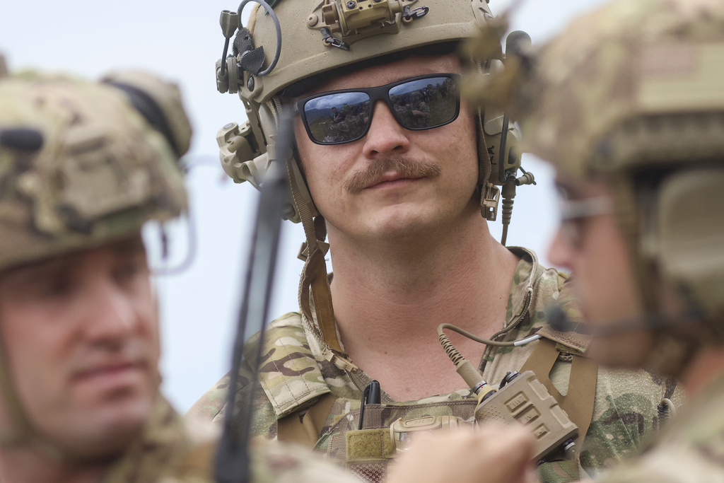 Soldiers of the US Army Airborne Division wait for the Air Force B-1B Lancer bomber flight 