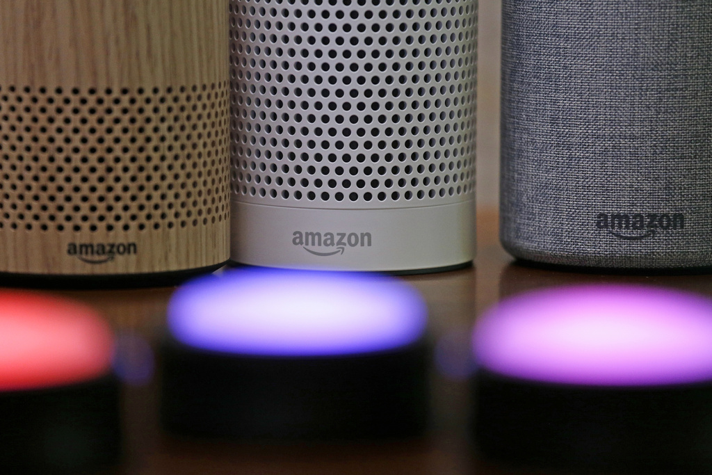 Amazon Echo and Echo Plus devices, behind, sit near illuminated Echo Button devices
