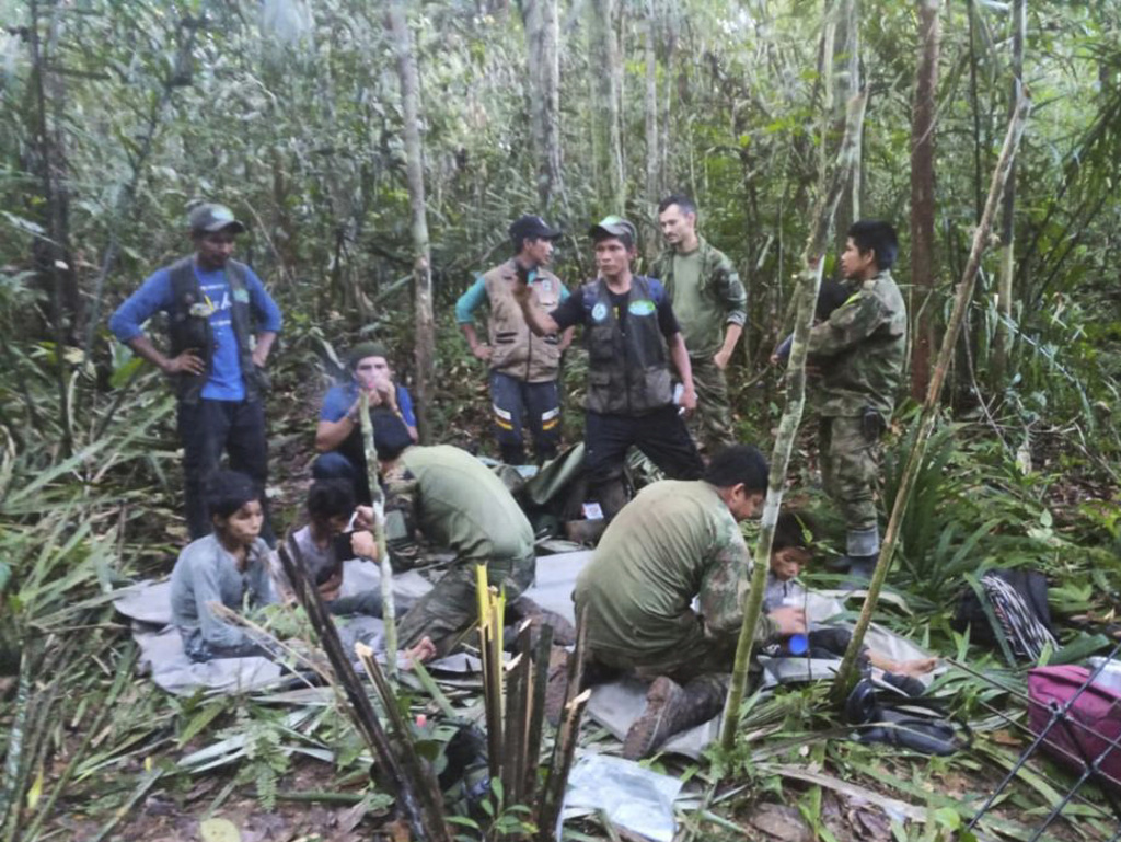 Soldiers and Indigenous men tend to the4 children who were missing after a deadly plane crash