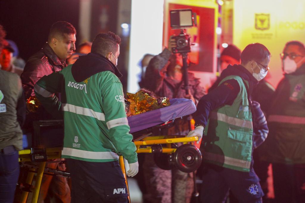 Paramedics carry to an ambulance one of four children who were missing after a deadly plane crash