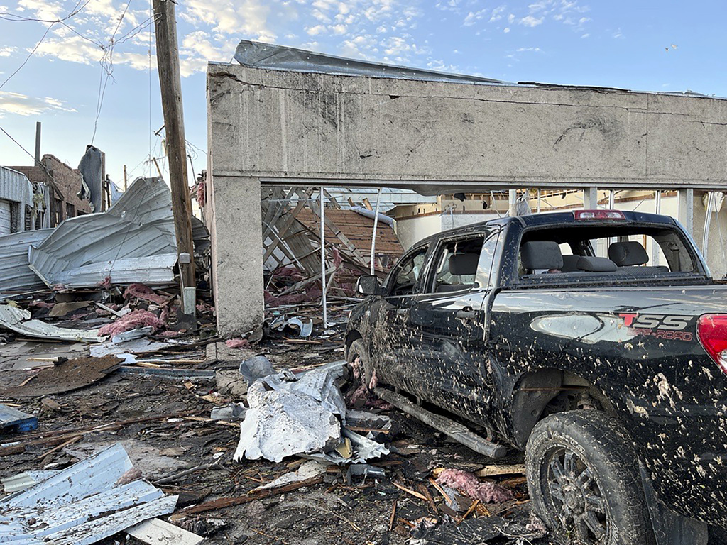 Buildings and a vehicle bear damage from a tornado in Perryton, Texas
