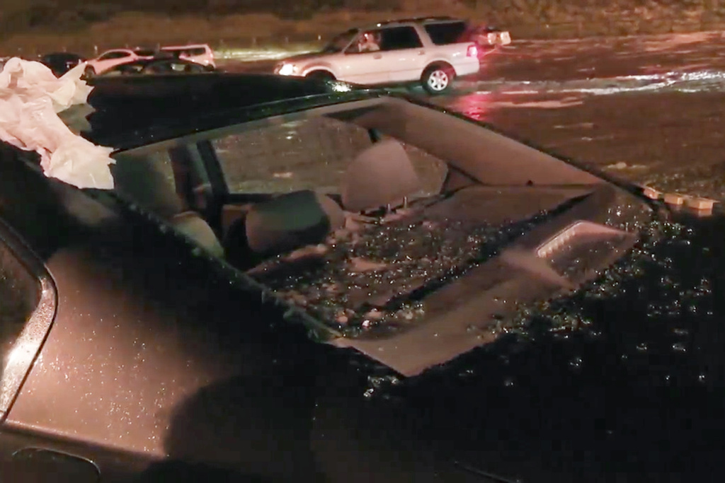 Hail shatters a window on a vehicle during a storm at the Red Rocks Ampitheatre near Denver