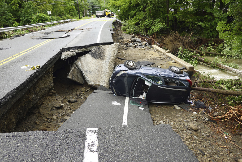 A damaged car lays on a collapsed roadway along Route 32 in the Hudson Valley near Cornwall, N.Y.