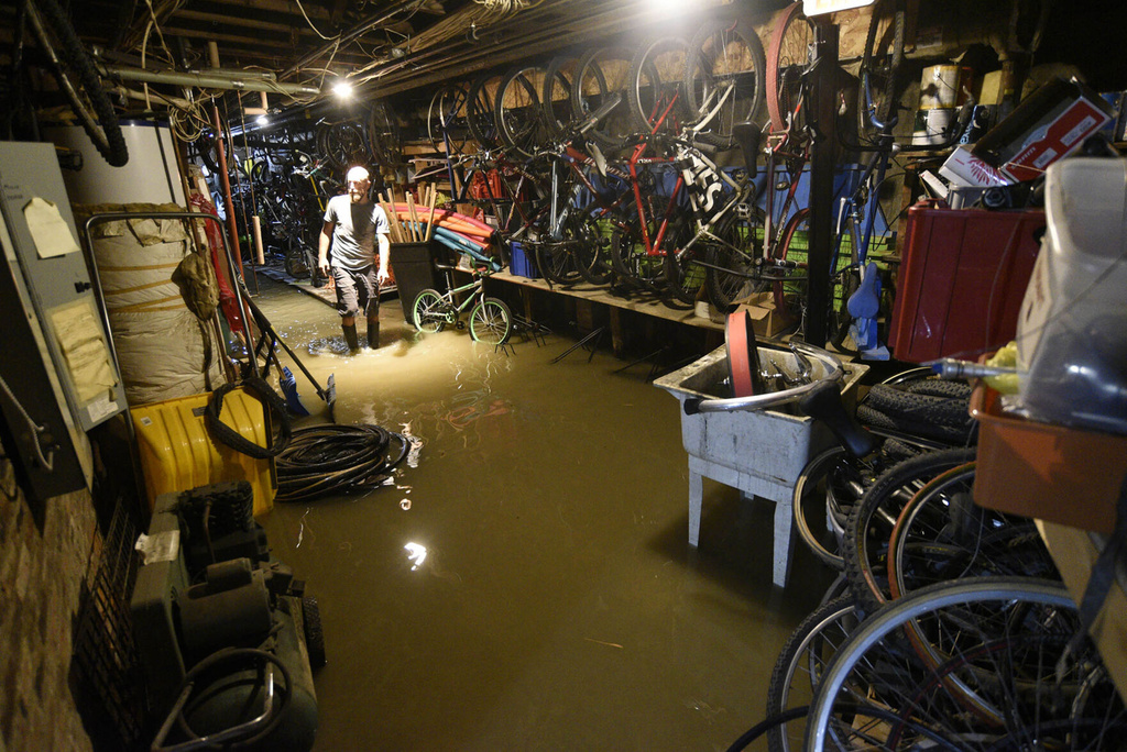 Kip Roberts, co-owner of Onion River Outdoors, wades through water in the basement of his Montpelier, Vt., shop 