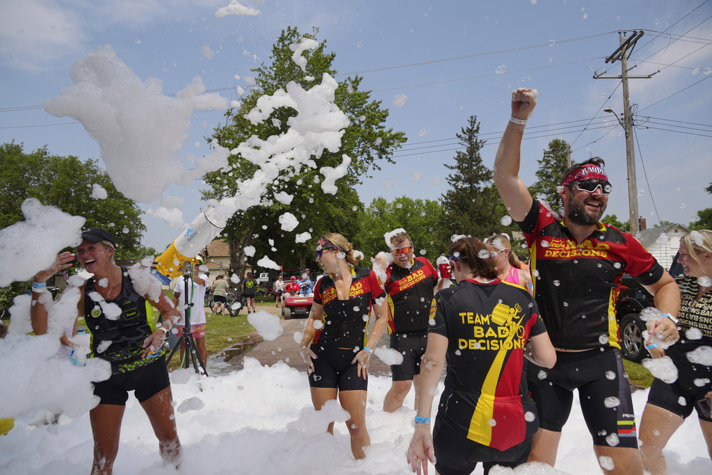 Riders, participating in RAGBRAI - the Register’s Annual Great Bicycle Ride Across Iowa- dance in a foam sprayer in Washta, Iowa