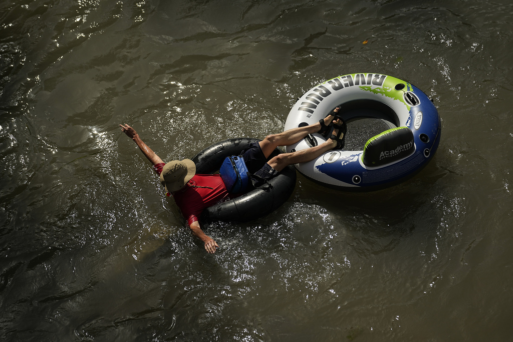 A tuber floats on the Comal River, July 26, 2023, in New Braunfels, Texas, as the area continues to feel the effects of triple-digit temperatures.