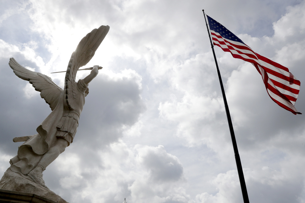 A statue of Archangel Michael, left, stands near a large United States flag at Russell Salvatore