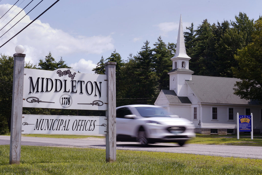 A car passes a sign outside the Middleton, N.H. municipal offices and Middleton Gospel Chapel, near a Dorsainvil family home