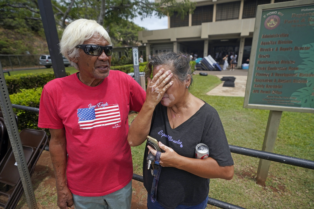 Myrna and Abraham Ah Hee react as they stand in front of an evacuation center at the War Memorial Gymnasium in Wailuku, Hawaii