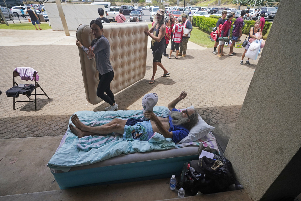 Thomas Leonard lies on an air mattress at an evacuation center at the War Memorial Gymnasium after his Lahaina apartment burned down