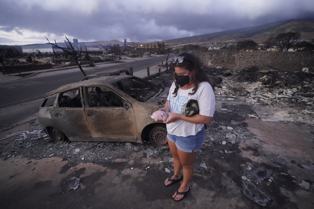 ummer Gerlingpicks up her piggy bank found in the rubble of her home following the wildfire