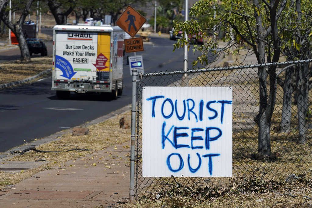 A "Tourist Keep Out" sign is displayed in a neighborhood in Lahaina, Hawaii