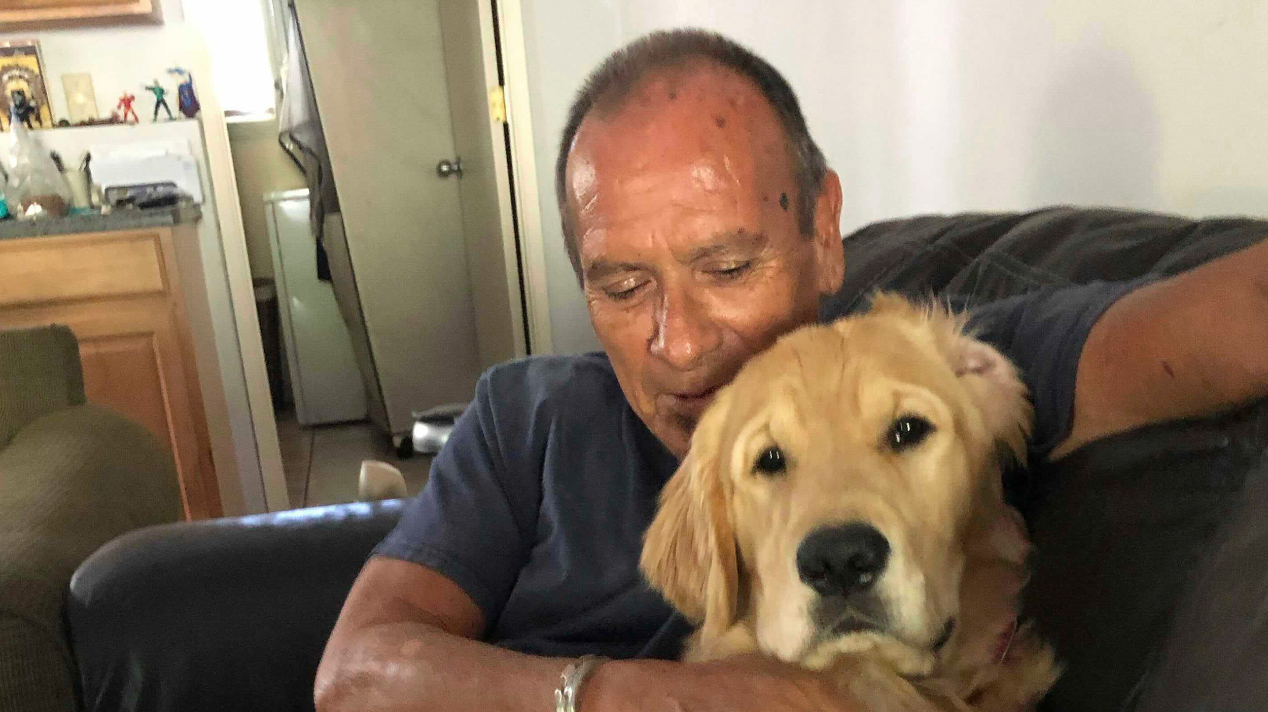 Man cuddling with his golden retriever