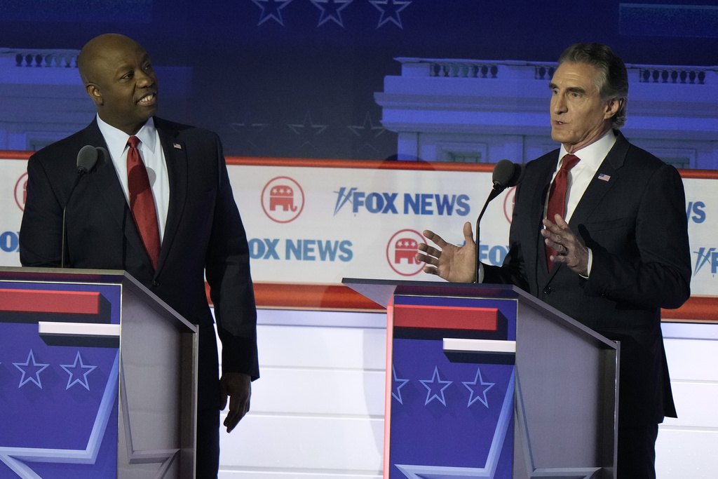 North Dakota Gov. Doug Burgum speaks as Sen. Tim Scott, R-S.C., listens during a Republican presidential primary debate