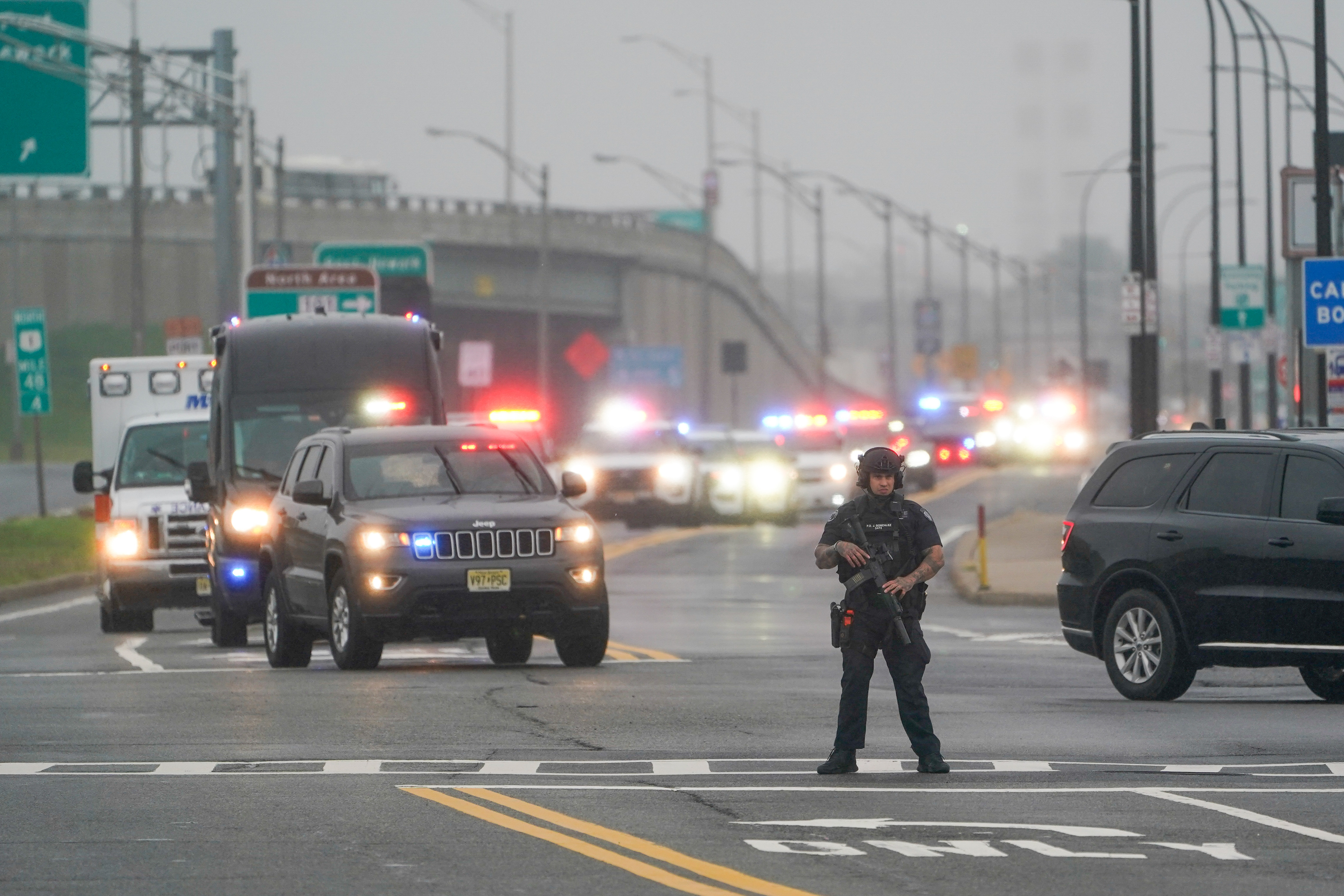 Police officer with motorcade in background