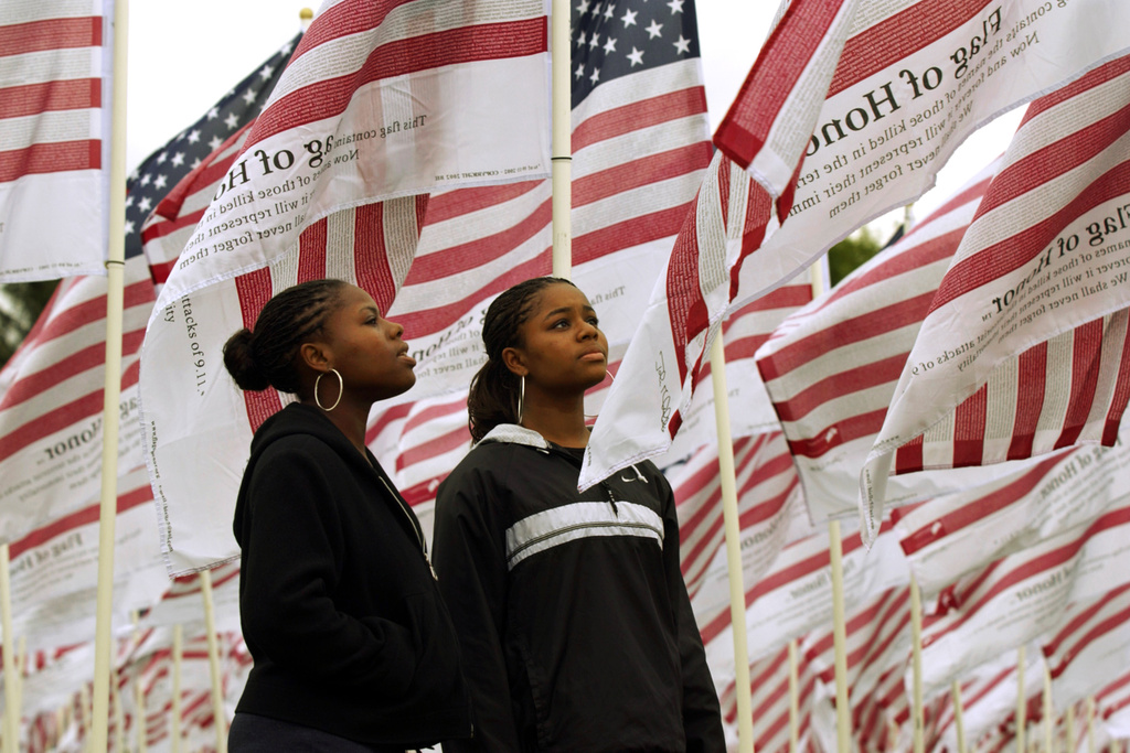 Identical twins Janita Ollison, left ,and Jeannetta Ollison 17, of Gresham Oregon, try to read some of the names of 9/11 victims printed on more than twenty -six hundred "Flags of Honor" erected as a memorial to represent each person killed by terrorist attacks, Sept. 11, 2001 in Gresham Ore.
