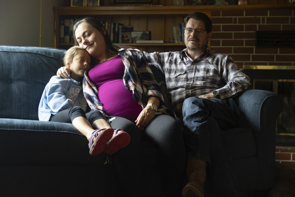Alisha Alderson and her husband, Shane, sit with their daughter Adeline, 5, in the living room of their house in Baker City, Ore.