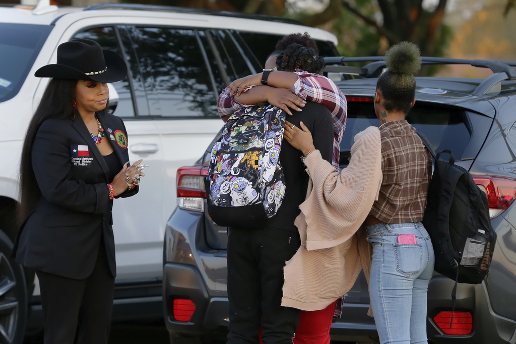 Darryl George, center left, a 17-year-old junior, and his mother Darresha George, center right, share a hug before walking across the street to go into Barbers Hill High School after Darryl served a 5-day in-school suspension for not cutting his hair 