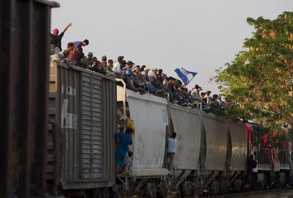 Central American migrants ride atop a freight train during their journey toward the U.S.-Mexico border, in Ixtepec, Oaxaca State, Mexico