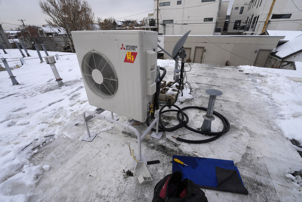 A condenser sits on the roof during the installation of a heat pump on Jan. 20, 2023, in Denver.