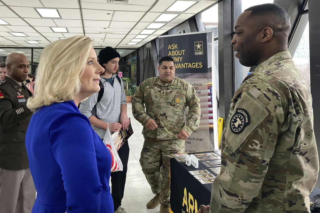 Army Secretary Christine Wormuth stops at an Army recruiting display after a speech to students at the Whitney M. Young Magnet High School in Chicago