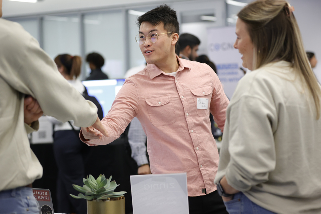 Georgia Tech student Michael Oh-Yang, center, greets company representatives at a job fair