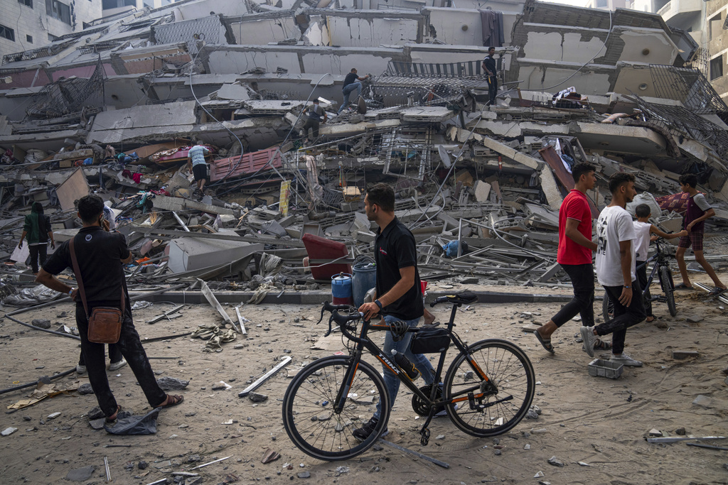 Palestinians inspect the rubble of a building after it was struck by an Israeli airstrike, in Gaza City