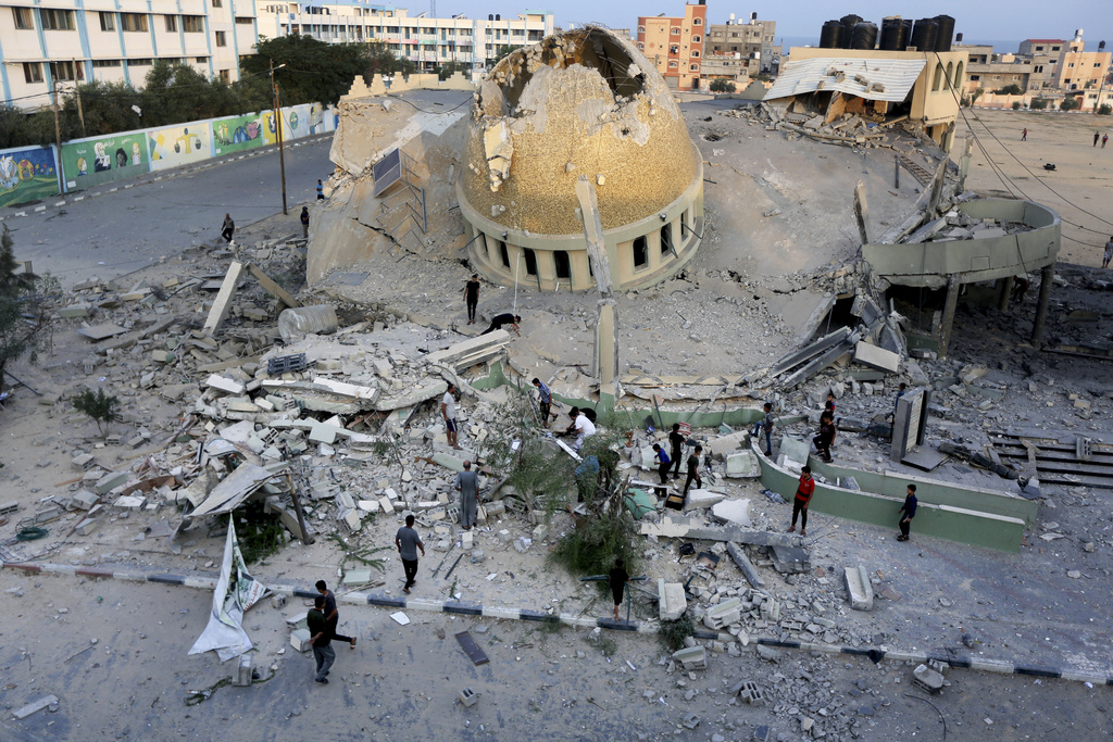 People stand outside a mosque destroyed in an Israeli air strike in Khan Younis, Gaza Strip