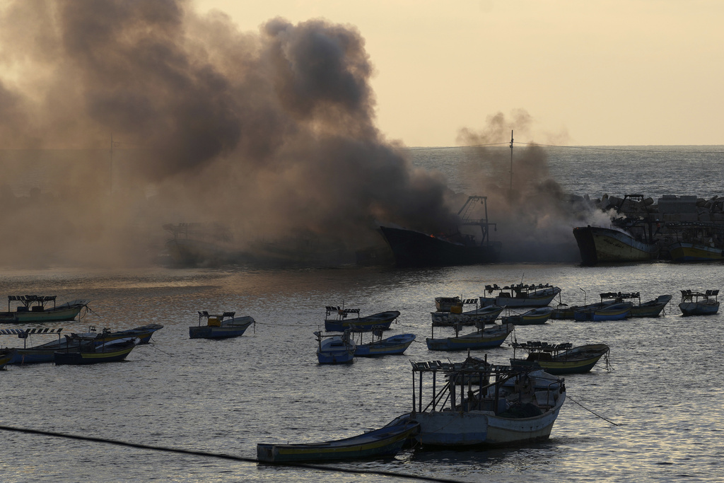 Smoke rises from burning fishing boats caused by an Israeli airstrike at the seaport in Gaza City